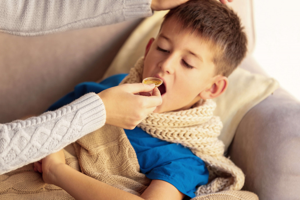 sick child eating honey for his cough